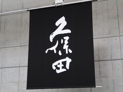 朝日酒造と言えば「久保田」。ラベルに書かれた、独特の久保田という書。これは、新潟県出身の書家の坂爪叟玄（さかづめそうげん）氏によって揮毫されたものです。
1830年に、平澤家の四代目当主の由右衛門は、酒造業の事業分割を図って、当時3歳になったばかりの次男の與三郎に酒造業をのれん分けし、屋号を「久保田屋」と称しました。この屋号が、まさに日本酒「久保田」の名前の由来となります。