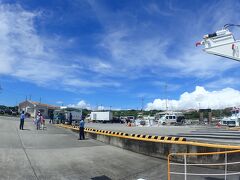 
今日は初めての津堅島に行きます

那覇市内からうるま市の勝連半島の先っちょまでは結構時間かかります

Google mapで調べると１時間ちょっとです

11時のフェリーに乗りたいので10時半頃到着したいってことで9時過ぎには出発します

早め行動が大好きです

ただスタッフから、今回の社員旅行中にどうしてもキングタコスが食べたいってリクエストもらってました

ちょうど勝連半島の海中道路の手前にキングタコス与勝店があります

以前行ったときはボロッボロのふる～い建物でしたが、道路挟んだ向かい側に新築されて移転してました

そこ寄って昼飯テイクアウトしたらいいじゃん！って思ったんだけど

なんとキングタコスのオープンが10時半です・・・間に合うかな？

スタッフ一人、オープン前のキンタコに置いて残りのメンバーをとりあえず港へ運んでフェリーのチケット買わせときます

そしてもう一度キンタコに戻って注文任せたスタッフをピックアップ！

急いで港に戻ってなんとか間に合いました

既に乗船は始まってたので、ほんとギリギリだったけどw