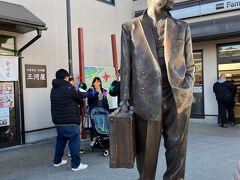 京成金町線の柴又駅前に立つトランクを持った寅さん。
