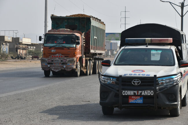 (8)我が車は「ガソリンスタンド」で給油中。警察先導車両は道路端に止まって警戒(1/15 11:20)<br />〇この地は「ハイデラバード」から、すでに「バロチスタン州」に入り「ガダニ船舶解体場」に向かう途中の「ガソリンスタンド」。<br />〇このガソリンスタンドでこれから先のテント泊用の「飲料水]も確保する。<br />