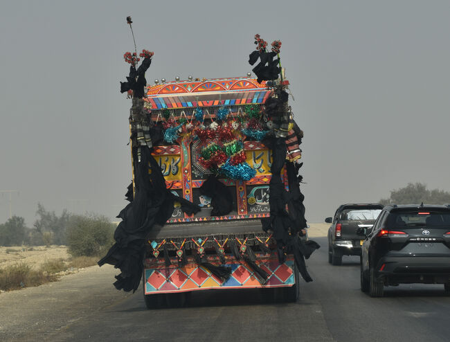 (18)インダスハイウェイを走行中の「デコトラ」(1/12「第2日目」)<br />〇黒布のヒラヒラは魔除けらしい。
