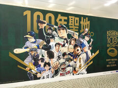 数年前から駅の西口で大規模な再開発が始まり、2029年頃まで工事が続くそうです。
西口地下広場を歩いていると、工事の仮囲いに甲子園100周年の広告がありました。
通路壁面のアート「新宿の目」の脇を抜けて、都庁方面に向かいました。
