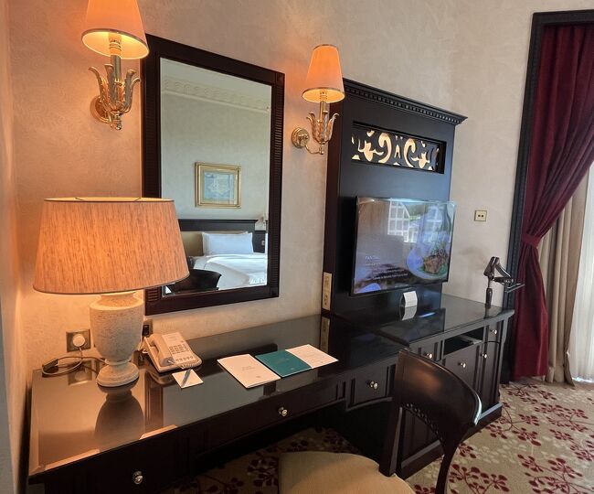 　机にはスタンド、電話、注意書きなど。