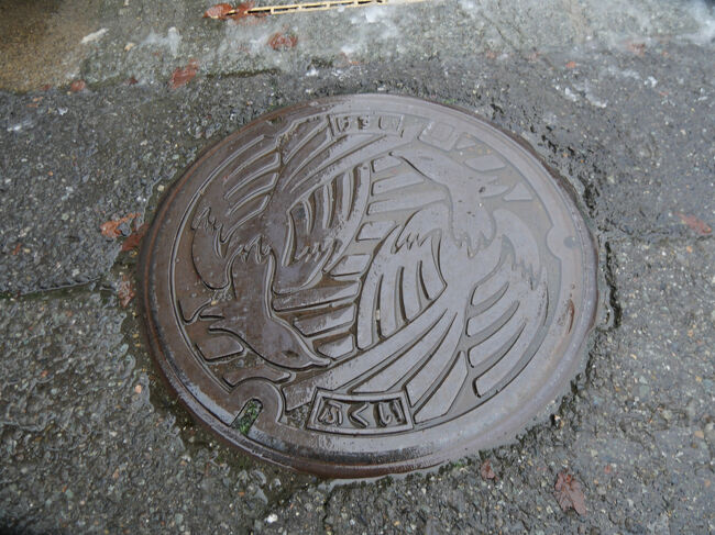 ホテルに戻ってキャリーケースを受け取り、JR福井駅に向かいます。<br /><br />写真は、ホテルから駅に向かう途中にあった、不死鳥のデザインマンホールです。