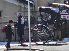 果たして人力車を体験することが出来るのかどうか気を揉みつつ眺めていた先に、約束通り、ゑびすやさんの人力車が、二人の車夫さんに導かれて到着

後からうかがったところによると、前日の８日は臨時休業、今朝は総出で道路の雪かきだったのだそうです
それでも氷状の雪はかききれず、人力車を引いて導く車夫さんと、滑りを押さえる車夫さんの二人掛かりで連れて行ってくださるとのこと
安全第一への配慮もありがたい、ゑびすやさん！
