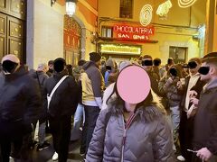 「チョコラテリア サン ヒネス(Chocolatería San Ginés)」

スペインの元旦に食べるものと言えば「チュロス」なんだそう！
ということで、1894年創業のチュロスの専門店へ。
へっ！？
お店の前には、100人以上が並んでいる…

とりあえず看板が見えるところまで掻き分けて、写真を撮って退散！