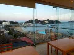 夕食は、1階の大広間でいただいた。
大きなガラス張りで、見晴らし抜群。
和具の船乗り場が見える。
小高い山は、多分首塚がある所。

過去に台風で、このガラスが割れたことがあるそうだ。
暴風雨が大広間に吹き込み、従業員が入口のドアを廊下側から押さえ、台風が通過するのを待った。