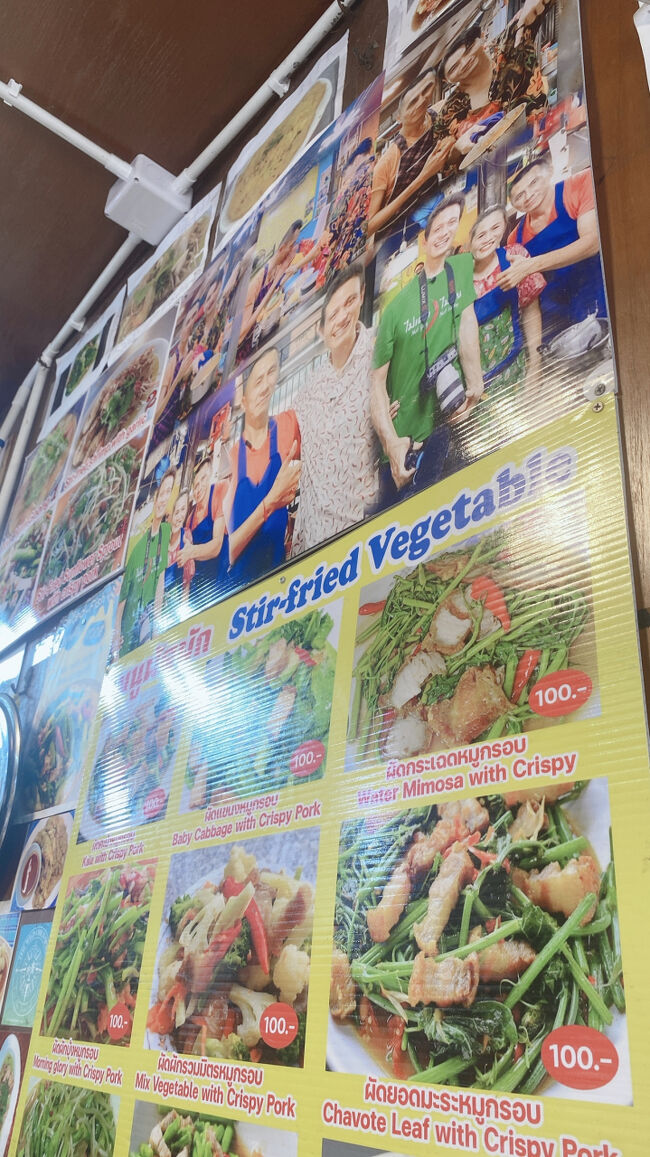 すぐ横の壁にもいろんなメニューが貼ってあります。<br />有名人の方もたくさん来店されているようで、店主さんと一緒に写っている記念写真もいっぱい貼ってありました。<br />本当に人気の有名店なんですね～！<br /><br />カイラン菜とか空芯菜も美味しそうだな～<br /><br />でも、悩んではいけない！<br />最初から食べようと決めていたものを食べないと絶対後悔するから笑