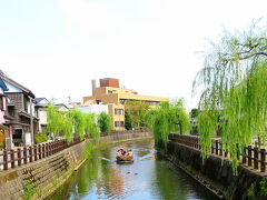 駅から歩くこと約600m、川岸通り（小野川）・開運橋に着きました。偶然にも観光客を乗せた舟が向かって来ます。きっと眺めが良いことでしょう。※30分ほどの舟めぐりを楽しめるそうです。（小野川観光船）