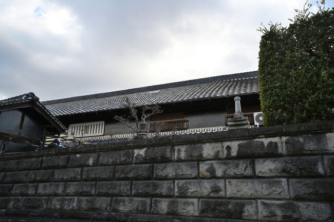 石塀の上に、春日灯籠や石塔が頭を出しています。