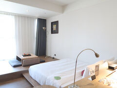 案内された居室は15階。
障害物がないので自然光が入る明るい居室。

ツインベッドルームをリクエストしていたけれど、希望かなわず、ダブルルーム。

ただ、居室は広い。
小上がりつきで面白いデザイン。

ベッドの後ろにカウンターデスクのような細長いテーブルが設置されて、作業するのに便利。
