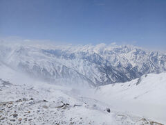 絶景の冬の北アルプスを目撃します。剱岳が聳えています。この写真を撮るためにグローブ外して短時間に稜線上に立ってみます。30秒ほどで顔が凍って皮膚の感覚を失くして、手が膨張しているのかグローブが入りません。少し先に唐松岳頂上山荘が見えますが、そこまでも絶対行けません。顔など少しでも露出している部分があったら、1分で凍傷になります。