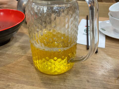 １６時くらいだったでしょうか。こうしてチケット無事ゲットと会場確認して、晩ご飯の「ティムホーワン添好運」に向かいます。このお店は、飲茶のお店で、ミシュランを獲得していて、世界で一番リーズナブルに利用できるミシュラン獲得店と言われています。セントラル駅近くのIFCモールの中にあります。

コンサート会場から徒歩５分くらいのバス停でバスを待つ間に隣で待っていた幼稚園児連れのママさんに「セントラル駅方面に行くバスは、ここで待てば良いですか？」と訊いたのですが、ママさんは、あまり英語が得意ではなさそうで、翻訳アプリに話してとスマホを向けても難しいようでした。で、どうも向こうのバス停留所から乗れと言っているようだったので、移動しました。気づくと一緒にママさんたちもバス停に来てくれていました。ここで小雨が降ってきてしまいました。
バス停前の屋根で雨宿りしながらバスを待ちます。10～15分くらい待ったでしょうか。ようやくバスが来て乗ります。バスは、前乗りで乗ってすぐに決済です。初めてオクトパスカードでタッチしました。

ママさんたちが下車します。わたしたちは、次の次のバス停で降りるよう教えてもらいました。ありがとう、ママさん。
ところが、降りたバス停は、少々セントラル駅には遠くて。(>_<)
徒歩５～10分歩いてやっと交易廣場に来ました。目指すIFCモールは、もうすぐです。
ところが、IFCモールの中でティムホーワンを聞いてもわかりません。デジタルのインフォメーションで検索しても出てきません。案内のコンシェルジュカウンターに行って聞いたところ「そのような名前のレストランは、この中にはありません。」と冷たい返事。ただでさえ、バスで目指す場所より遠くに着いてしまい、暑い中、だいぶ歩きました。もう誰に訊いたらいいのか、途方に暮れました。で、思いついたのが、香港駅のカスタマーセンターです。IFCモールからエスカレーターを降りて香港駅に行ってカスタマーセンターを探します。すぐに見つかりました。
「ティムホーワンレストランへの道をお訊きしたいのですが。」と言うと
カウンターのおじさんは、「ああ、それはね、IFCモールへ行くエスカレーターを上ったらすぐに右手に別のエスカレーターがある。エアポートエクスプレスへ行く方のエスカレーターだよ。そのエスカレーターを降りたショッピングモールにありますよ。」と親切丁寧に教えてくれました。(^^)
実は、ティムホーワンは、IFCモールではなく、MTR香港駅のショッピングモールの中にあります。隣接していますが、全く別の建物ですので、間違えないようにご注意ください。
ここでの教訓は、信用できる確かな情報の人に道は、訊かないといけないということでした。(>_<)
　まあ、こうして迷いに迷って何とかティムホーワンにたどり着きました。
１７時くらいの到着を見込んでいたのに１９時を過ぎていました。２時間もさまよっていたんです。ポジティブに考えれば、お店は混雑していなかったので、行列も無くすぐに座れ注文することができましたので、ラッキーだったのかな。
注文数の記入欄付きメニューで、注文は、簡単でした。
暑い中歩き回ってお茶は、冷たい白桃ウーロン茶をお願いしました。
大きなジャーに入ってきたのに一気に減る勢いで飲みました。
