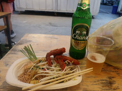 外の店でタイビールのチャンと焼きそば（パッタイ）を食べる