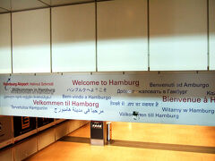 羽田から乗ったミュンヘン便は隣の年配ドイツ人カップルの女性がずーーーーっと咳き込んでいてヤバかった。
うつさないでね････、帰りの便ならいざ知らず、これから海外旅行始まるんだからね、私。
この女性（窓側席）、咳はするけどミュンヘンまで一度も席を立たず。
すごい膀胱を搭載しているな。　　是非譲って！
カップル男性（真ん中席）は2度ほどトイレに立っていた。
私は通路側席。ちょっと咳き込み女性と離れているけど、旦那さんと話すときこちらに顔を向けるので、飛沫が･････。

ミュンヘン空港での出発ゲートが2度も変わり、そのたびにモノレールで行ったり来たりして乗り継いだハンブルク空港。ターンテーブルへ行くまでの所に各国語で歓迎の文字が。