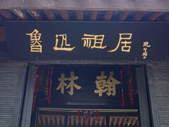 「紹興」には昔から伝わる「3つの黒いもの」があります。「3つの烏（からす）」とも言われていて、どれも紹興を象徴するものです。
１つ目は先ほど見えた「烏篷船（うほうせん）」で、夜の漁で魚から舟が見えないように黒く塗られています。2つ目はこの「烏毡帽（うせんぼう）」です。3つ目は「烏干菜（うかんさい）」で、高菜やからし菜を細かく刻んで天日で干したもので、この乾燥した菜っ葉と豚肉を炒めると真っ黒な料理が出来上がります。