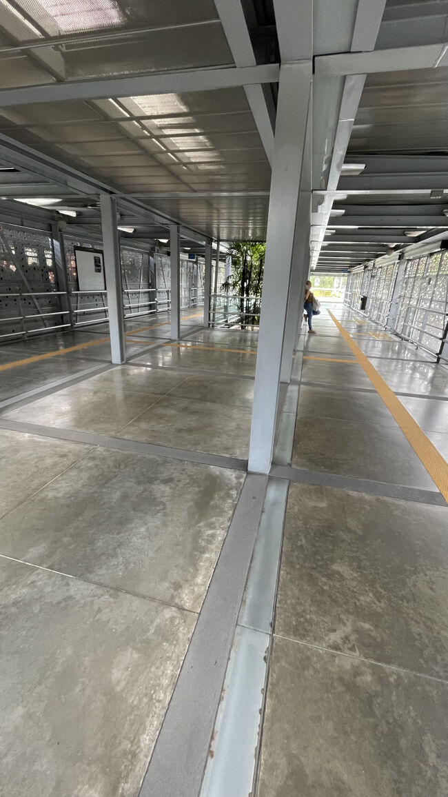 さて。メデジン、何から始めよう。。。ということでかつてギャングが支配していたComuna 13(コムナトレセ、13番地区、みたいな感じ)の無料ツアー（チップのみ）に参加してみることにしました。<br /><br />集合場所まで結構遠いですが、バスと電車（メデジンにはメトロが通っている！地下に潜らないけど）で行くことにしました。<br />この写真はバス停。檻みたいに囲われてて安全を感じました。<br />バスも電車も共通のカードで乗れます。<br />バス停の入り口で購入できます。