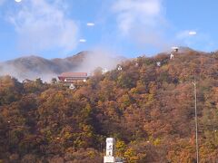 写真：戸倉上山田温泉・城山

「戸倉上山田温泉」は、長野県・北信エリアの南西部に位置する千曲市の中央を蛇行しながら南北に横断して流れる長野県を代表する一級河川として知られる"千曲川"を挟んだ両岸エリアに整備されている温泉街です。
「戸倉上山田温泉」の歴史については、"信越線"（現：しなの鉄道）が開通した当時の１８８８年（明治２１年）に江戸時代より"北国街道"の宿場として栄えていた旧・下戸倉村に停車場が設けられなかったことで村の衰退に危機感を抱いていた地元出身の坂井量之助が、明治期初頭に"千曲川"の河川敷で湧き湯が発見されていたことに着目し、私財を投じて"千曲川"の中洲で温泉を掘り当てて１８９３年（明治２６年）に「戸倉温泉」を開湯したことがはじまりとされています。
ちなみに坂井量之助は、旧・下戸倉村において安土桃山時代後期から江戸時代初期となる慶長年間（１５９６年から１６１５年）に創業したとされる酒蔵（坂井銘醸）の１５代目・当主であり、「戸倉上山田温泉」の温泉街では"温泉の開祖"と称されています。
また開湯から１２年後の１９０５年（明治３８年）に坂井量之助が享年４６歳でこの世を去りますが、その後の１９１２年（明治４５年）になると地元の要望による請願駅として"戸倉駅"が開設されています。
「戸倉温泉」の開湯後については、"千曲川"の度重なる水害に見舞われていた温泉旅館施設が１９０２年（明治３５年）の水害により流失したことで"千曲川"の右岸（東側）に移転しており、その翌年となる１９０３年（明治３６年）には"千曲川"の左岸（西側）においても温泉が掘り当てられ「上山田温泉」が開湯しています。
さらに１９１６年（大正５年）になると"千曲川"の川岸に堤防が整備されたことを機に「戸倉温泉」が右岸（東側）から左岸（西側）に移転するとともに長野県を代表する寺院である善光寺（長野市元善町）の"無差別平等の救済"の教えとされる"誰でも極楽往生できる"とする考えから江戸時代より庶民の信仰を集めて人気となっていた善光寺詣りの"精進落としの湯"として親しまれるようになり信州屈指の温泉街が形成されています。
現在では、"千曲川"左岸（西側）の「戸倉温泉」および「上山田温泉」さらに右岸（東側）の「新戸倉温泉」を総称して「戸倉上山田温泉」と呼ばれており、温泉街エリアの各所において５２箇所の源泉が存在しています。
「戸倉上山田温泉」の泉質については、かすかに硫黄の香りがする無色透明のアルカリ性単純硫黄泉で、刺激が少なく肌の角質を軟らかくさせる成分が含まれていることから"美肌の湯"として親しまれています。
また「戸倉上山田温泉」を見下ろす温泉街の西側に位置する城山の中腹には、夜になるとネオンが灯る"戸倉上山田温泉"の掲示板が設置されており、今なおスナックなどの飲食店および射的場などの遊興施設が残る昭和レトロな雰囲気が漂う温泉街を引き立てています。