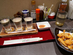 駅へ戻ると、まだ小一時間ほどある。そこで、駅構内にあった土産物屋を覗くと、そこに食事処があった。地酒も呑めるというので、昼食代わりに立ち寄ることにした。三種飲み比べと、イカの唐揚げを注文。お酒は、地元上越市の『吟田川 特別純米』と『妙高山 特別純米』、そして、妙高市の『千代の光 純米』であった。