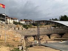 住宅地を通って古代劇場にやって来ました
坂が続いて、ハアハア、ゼイゼイ…
それを見てガイドさんが、オフリドの地名の由来は「hill(丘)」から来ているんだよ～と笑

こちらの古代アリーナが建てられたものは紀元前200年頃。マケドニアに現存する3つの古代劇場のうちの一つで、オフリドの旧市街にあります。現在はアリーナの下の階が残っているだけですが、かつては上階もあり今より大きなものだったそうです。どれだけの観客を収容できたか正確な数はわかっていませんが、4000席はあったといわれています。

ローマ帝国時代にはグラデュエーター達が闘い、その後キリスト教の処刑場として使われた歴史があります。そのため周辺住民からは忌み嫌われ、ローマ帝国崩壊後は長く放置され、そして地中に埋められてしまいました。

1980年代に偶然にも発見され発掘修復されて今の姿となり、現在は夏場にはフェスティバルやコンサートが催され観光客にも人気です。
掲げている国旗は旧マケドニア国旗のようです