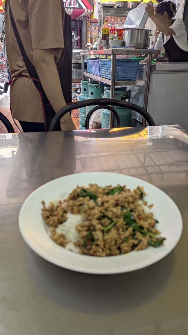 お昼ごはんはセントラルパタヤから徒歩10分ほどのソイブッカオ名無し食堂<br /><br />お店の探してうろうろしてたら欧米中年男子に声かけられた。<br />足の悪い高齢者に親切な人だったのかもしれないけど、向こうから話しかけて来る人は基本的に警戒することにしている。<br />パタヤはおひとりさま中高年男性が多い印象。<br /><br />旅友がおススメしてくれたお店でメニューがすごく多い。<br />チャレンジ精神がないので定番の豚肉のガパオライスをオーダー　50バーツ（ピント合っていない）<br />お店の人が「辛いの大丈夫？」って聞いてくれたので、「少し辛くしてください」とお願いした。<br />クルワンプルーンの酢漬け唐辛子がおいしかった。<br />目玉焼き付けてもらえばよかったと食べ終わってから気がついた。