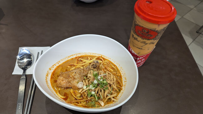 お茶は持ち帰りにして、3階のPier21へ。<br />プリペイドカードに現金100バーツチャージしてもらってカオソーイを注文<br />55バーツ<br />お店の端末にプリペイドカードのQRコードかざして支払い。<br /><br />カオソーイのお店で並んでた時、お隣のお店で受け取ったお料理ひっくり返しちゃった人がいて床が大惨事に・・・。<br />お料理運ぶ時気をつけようと肝に銘じた。<br /><br />ちょうど夕食時で結構混んでたけど、4人席を利用していた欧米高齢ご夫婦に相席させてもらった。<br /><br />出発前からカオソーイ食べたいなーって思っていたのでフードコートで食べられてよかった。<br />そんなに辛いお料理だと思っていなかったんだけどすごく辛くて、ミルクティー飲みながらおいしくいただいた。<br /><br />欧米ご夫婦が去った後、韓国系ファミリー4人が空いている3席をキープして私が食べ終わるのをすごく待っている様子だったので急いで完食。<br /><br />フードコートのプリペイドカード残高45バーツ払い戻してもらって・・・