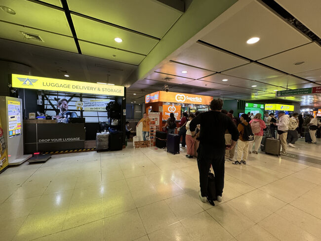 空港地下。黄色の看板は荷物預け所で右側は両替所。