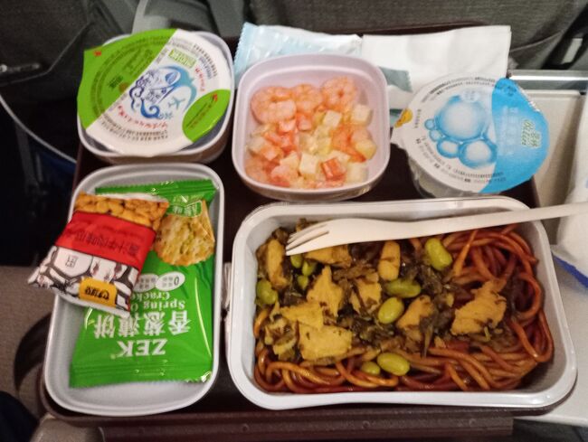 こちらが上海からの便の機内食。<br />上左は小豆のスイーツ、茹で小豆のの様な感じだが余り甘く無くまあまあ美味しい。<br />上中央は小エビのサラダ。<br />上右は水。<br />メインは焼きそばだったのですがこの手の焼きそばはいつも脂っこい。味が悪いわけでは無いのですが。<br />お菓子の小袋が2種類。<br />それなりに工夫をしているなあ～と思いました。