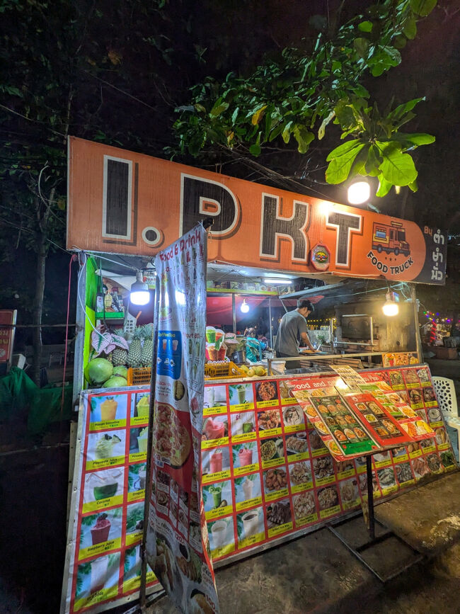 少しお腹が空いていたので、ホテルの近所を散策するとします。<br />雨が降っているなぁ。<br />ホテルから徒歩5分ぐらいで、海沿いにレストランや屋台が並んでいる。<br />ピンとくるレストランがないので、屋台飯をテイクアウト。<br />こちらの屋台はひっきりなしにフードデリバリーのバイクがピックアップにきていたのでまぁ安全かなと。旅行初日からお腹壊したくないので整腸剤必須。