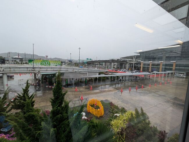 入国はスムーズ。2025年5月より紙の入国カードが全面廃止、3日前からオンライン申請します。<br />https://www.thailandtravel.or.jp/tdac/<br /><br />荷物を受け取り後、Grabアプリから予約。<br />この写真の奥が国際線ターミナル、国内線ターミナル前にあるGrabステーションへは徒歩3分ほど。写真に写ってる屋根付きの歩道からアクセスできます。