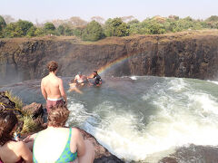 デビルズプールの様子。
ここでは、ゲストを誘導サポートするスタッフと撮影係のスタッフで対応。
滝上の縁では、必要に応じてスタッフが足を持って転落しないようにサポートする。
プールの中では小魚が肌をつついてくるが、暴れないようにあらかじめ注意される。
実際には気持ちが高ぶっているので、魚のことなど気にならなかったが。
(カメラ返却後、次のグループを撮影)
