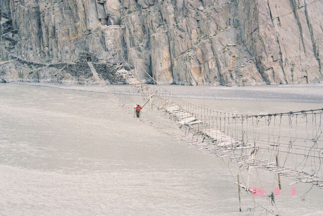 　パスーにある、フンザ川にかかる吊り橋。フンザ川はインダス川の支流。流れは強く、渦をまいて流れている。恐る恐る、ロープにつかまりながら渡るが、向こう岸から女の子がすたすたわたってくるので、すれ違うのを避けて戻ってくる。向こう岸は絶壁で、 絶壁に階段状の道がついている。