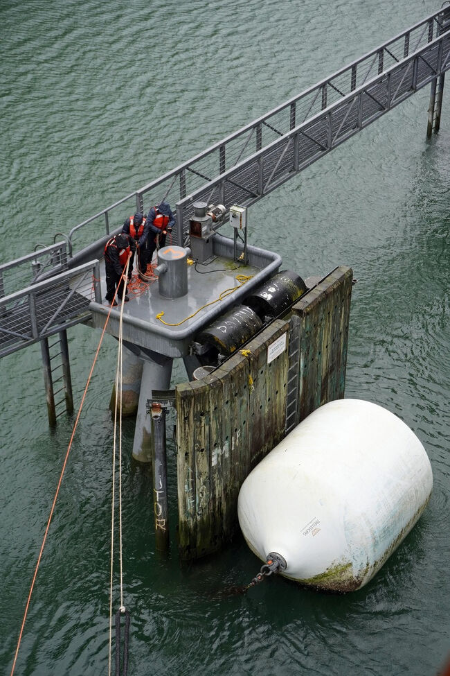 3人の港湾作業者がロープを手繰り寄せて、係留ロープまでもう少しです。