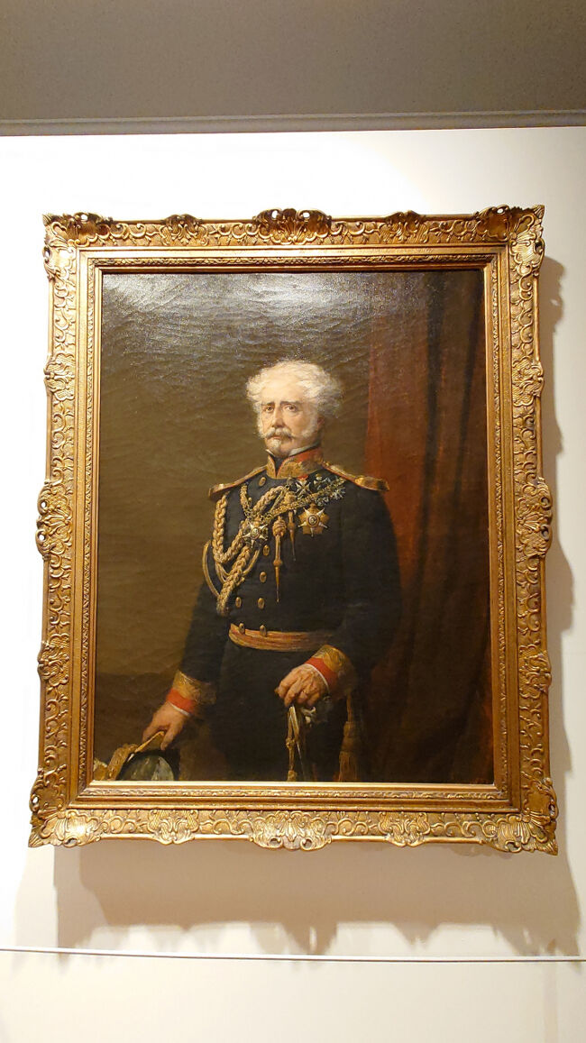 初代ペルネス男爵で 1834 年のペルネスの戦いで勇敢に戦ったペドロ パウロ フェレイラ デ ソウザとその妻ヘレナ デ アゲダ ボン男爵夫人。<br /><br />1870年から1880年にかけてブルジョワ社会の肖像画を描いたミゲル・アンジェロ・ルーピは、ポルトガルにおける肖像画における写実主義の先駆者とされています。画家は、色彩のグラデーションを背景に二人の人物像を際立たせ、奥行きのある印象を与えています。<br /><br />この夫婦は男爵の死から11年後に描かれているため、画家は男爵を描くためにイメージに基づいて作業を進め、妻は画家のためにポーズをとったと考えられています