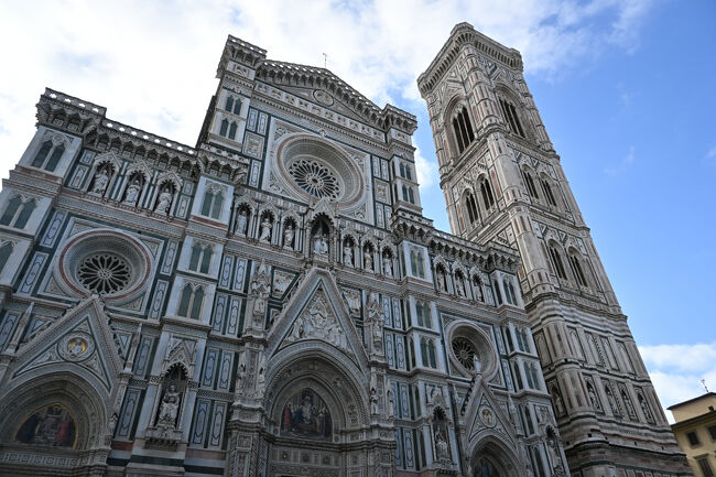 この町のシンボルといえば、旧市街の中心にそびえ立つサンタ・マリア・デル・フィオーレ大聖堂である。イタリア到着以降、「サンタ・マリア」が各地でいくつも出てきてとても覚えられないが、「イタリア旅行のパンフレットやガイドブックの表紙を飾るあの巨大なレンガづくりのドーム」といえばすぐにわかるだろう。<br />まずは教会の正面玄関前から外観を観賞。ヨーロッパの教会の外観は単色、装飾少なめで内部に比べ地味なことも多いが、こちらはかなりのインパクトである。派手とか地味とかいう以前に、ただ異彩。なかなか他ではお目にかかれない感じだ。若干のテーマパーク感もある気がする。