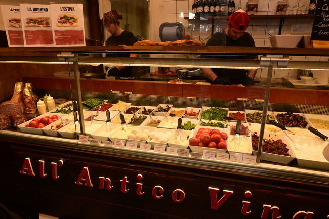 店で夕食を食べる時間はないため、駅のなかで食料を調達しようと思っていたところ、パニーニの有名店「All'Antico Vinaio」を発見。本店はウフィッチ美術館の近くにあり、一日中行列の絶えない人気店だという。オリーブオイルの染みたサクッとしたパンに切りたてのみずみずしい生ハムが惜しげもなくはさんであり、できたてならではのフレッシュ感がある。さすがのクオリティであった。
