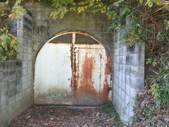 階段の中腹を台地の形から「イタリア半島」とも呼ばれた宮前台地方向に進むと、鉄扉がある地下倉庫入口のようなものがあるが、日吉台地下壕の戦争史蹟。
以前は、戦時中に海軍が掘った防空壕の出入り口や換気口が、あちこちに残っていた。これは海軍の連合艦隊司令部が、東京湾上の軽巡洋艦大淀からこの上の第一校舎に移転してきたためで、司令部要員などが空襲時も勤務できるようにするために掘られたとされる。総延長は5,000メートルもあるらしい。