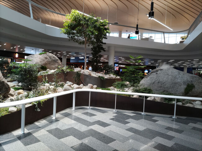 この日は出発ですが、ヘルシンキ・ヴァンター国際空港の到着ロビー<br />中央に小さな庭のようなモニュメント<br />周囲に飲食店