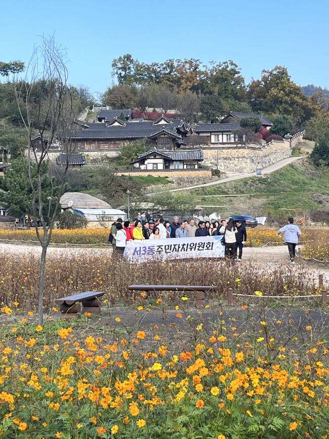 「住民自治委員会」と書かれた旗を持って記念撮影<br /><br />自治委員会の遠足なのかな