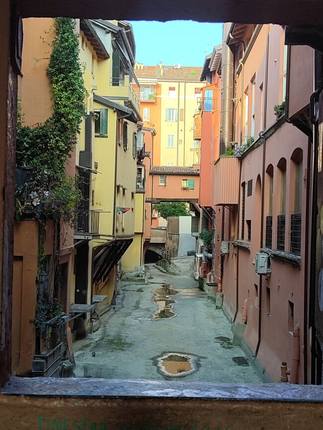 歴史的な旧市街地にある3つ星「ホテルチェントラーレ」を予約していましたが、駅からホテルに向かう道が凄い人出( ;∀;)<br />人込みの中を大きなスーツケースを引いて歩いて疲労困憊((+_+))<br />こんな事なら、もっと駅近のホテルを選べば良かったと後悔。<br /><br />でも、ホテル近くのポルティコにある窓からこんな景色が望めました。<br />「見たことあるかも？この景色…」