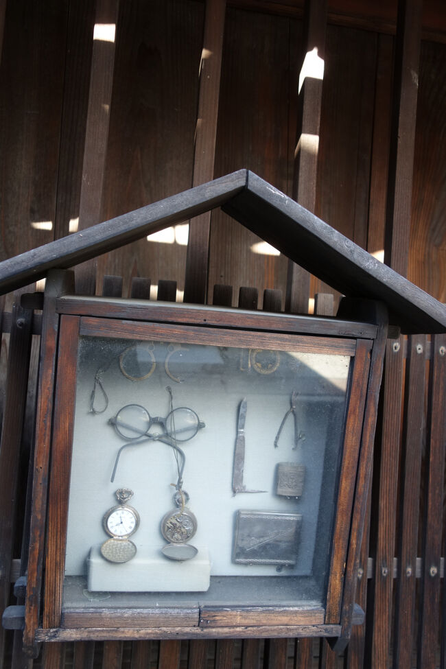 まだガラス張り店舗などない時代。<br />どんな商いをしているか分かるような看板代わりに陳列していたのかな。<br />眼鏡や時計などの精密機器のお店だったみたいですね。