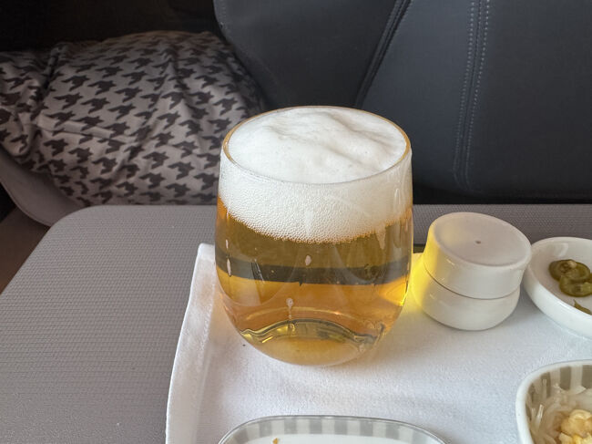 ビールは無いのかと聞いて、タイガービールをゲット。久々に機内でビールを飲みました。<br />ビールには細長グラスの方が好きです。