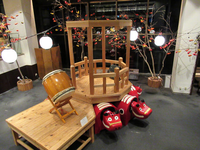 ロビーから階段を降りた所には赤べこと舞台、その周りには柿の木が・・・