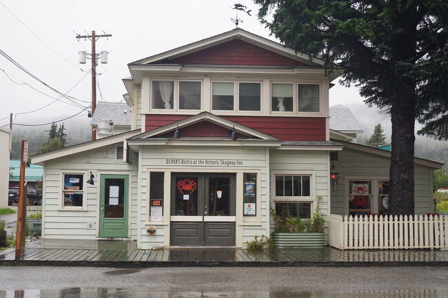 かなり町外れ迄歩いてきました。この先はもう住宅地といった感じです。この建物はスキャグウェイ・インという宿屋で、「オリビアズ・ビストロ/Olivia’s Bistro」の文字と赤いタラバガニがそそりますが営業時間外です。