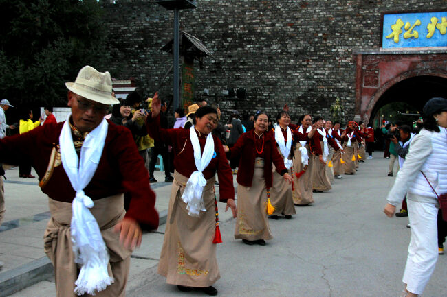 ★秋の九寨溝絶景紀行（６）～松藩県：松州古城：北門城外<br /><br />チベット人踊ての首にみな白いスカーフをしています。<br />これはカタと言いカタは、相手への尊敬や感謝、純粋な心を<br />表す贈り物です。お祝いの席だけでなく、何かを祈る時や、<br />大切な人との別れの時にも贈られます。<br /><br />踊り手の人達は観顧客も一緒に踊ってくれた人などに<br />このカタを贈っていました。<br />正式には素材は絹だそうですが、一般的にはポリエステル等の<br />化繊素材のカタだそうです。<br />