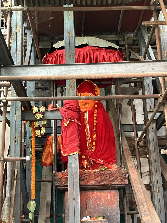 旧王宮が「ハヌマン・ドカ」と呼ばれる由来になったハヌマンの像。修復の足場に囲まれ、そして像そのものは赤いマントに覆われ、ハヌマン様のお姿はちっとも見えませぬ。<br />この右手にハヌマン・ドカの入口があって、そこにも獅子に乗ったハヌマンの像が対で置いてあったはずですが、修復工事のためまったくわかりませんでした。