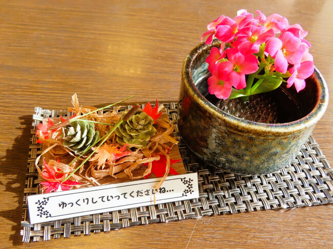 小さな鉢植えと、折り紙などで作られた紅葉の落ち葉の演出