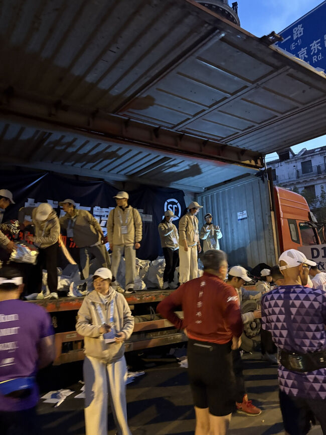 ここに荷物を預けます。<br />色々丁寧に教えてくれます。<br />エキスポで受け取った袋にゼッケン番号のシートを差し込み、上部を縛ってから渡します。