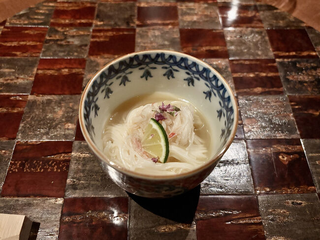 蟹　にゅう麺　酢橘<br /><br />地元で水揚げされた金目鯛から出汁を取った蟹にゅうめん。さっぱりとした酢の物としての位置づけでしょうか。<br /><br />丸盆は「桜総皮（そうかわ）盆市松」。山桜の樹皮を用いて作られる秋田県角館の伝統工芸「樺（かば）細工」の製品です。