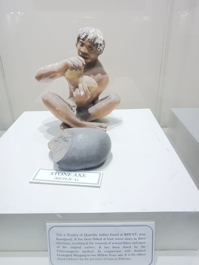 博物館には、先史時代からインダス文明にかけての史物が沢山展示されています。<br />人形の手前は、ラワルピンディー近郊のRIWATで発見された斧として使われていた珪石(レプリカ)です。古地磁気法による年代測定から約200万年前にパキスタンに人類が存在していた証拠品とのこと(説明版)。初人類出現とされるネアンデルタール人は、約50万年～30万年前にいたと言うから、それよりもず～と前のことになります。もしかしたら類人猿が使っていた道具かも知れません。推測ですけど。。。